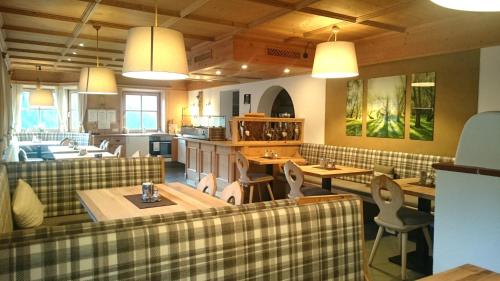 a restaurant with tables and chairs in a room at Bio & Reiterhof der Veitenhof - Pferde, Berge, Wellness & Freiheit im Ötztal in Niederthai