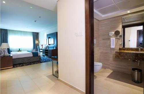 a hotel room with a bed and a bathroom at Hotel The De - Pacific Suites Near Delhi IGI Airport in New Delhi