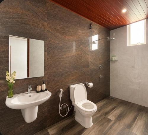 a bathroom with a toilet and a sink at Bravon Sky Hotel in Kurunegala