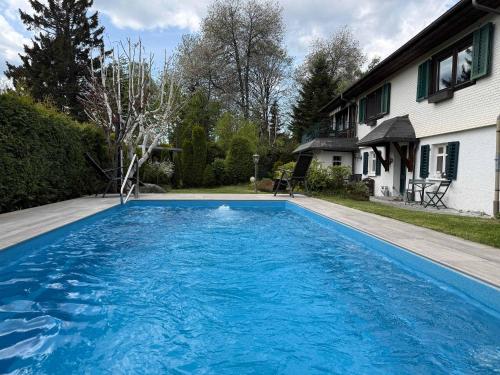 a large blue swimming pool next to a house at Haus am Rotkreuzweg mit Pool in Feldberg