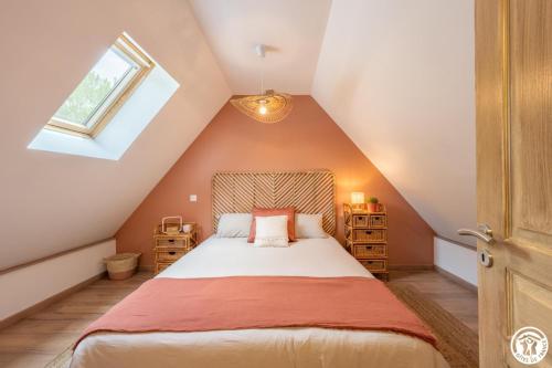 a attic bedroom with a bed and a window at Le beloiseau in Breteuil