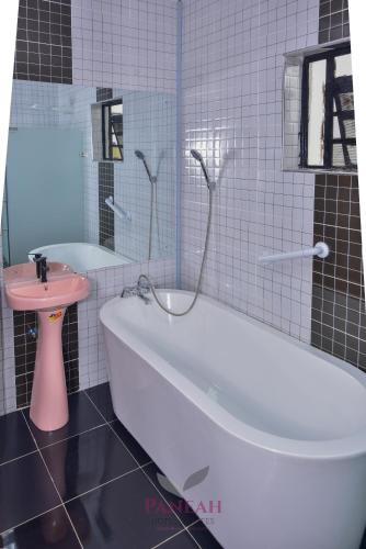 a bathroom with a white tub and a pink sink at Paneah hotel and suites in Nairobi