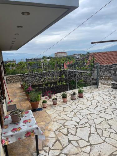 a patio with potted plants and a stone wall at Stone House Leskovik in Leskovik