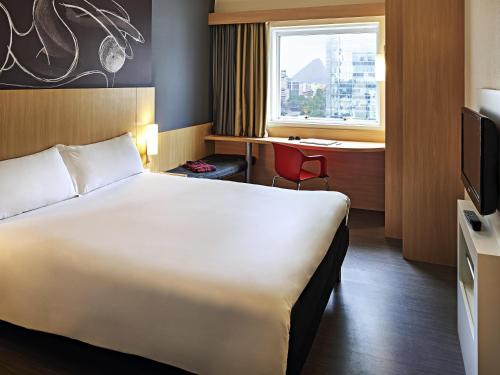 a hotel room with a large bed and a window at ibis Rio de Janeiro Centro in Rio de Janeiro