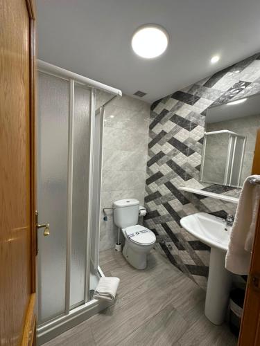a bathroom with a toilet and a sink at Pensión Mencia in Lugones