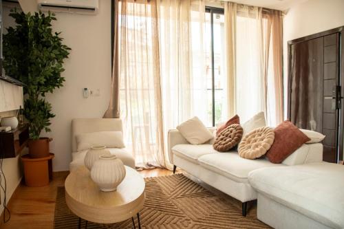 a living room with a white couch and a table at Residence Hôtel le Danoré Bastos in Yaoundé