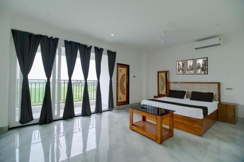a bedroom with a bed and a large window at SPOT ON Golden Eagle Residency in Barpeta