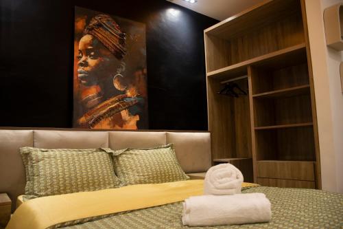 a bedroom with a large painting of a woman at Residence Hôtel le Danoré Bastos in Yaoundé