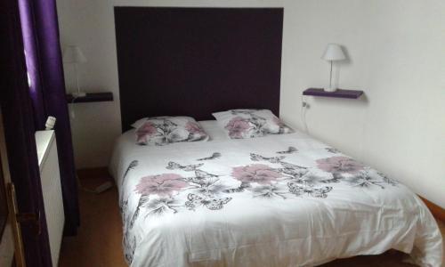 a bedroom with a bed with pink flowers on it at Entre Terre et Mer in Oye-Plage