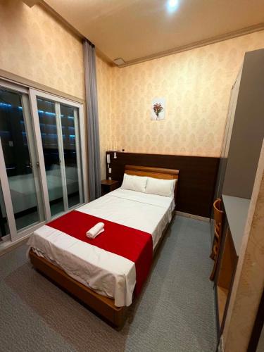 a bedroom with a bed with a red blanket at Regency Sunset Condotel in Angeles