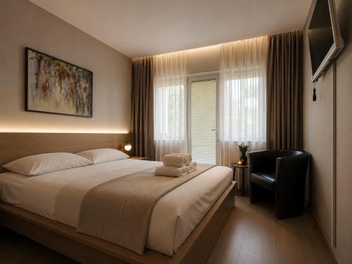 a bedroom with a large bed and a chair at Hotel - Pension Vesta in Bad Elster