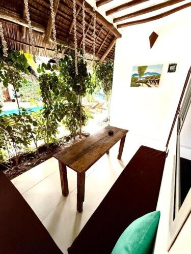 a room with a wooden bench in a room at King Simba Apartment Hotel & Restaurant in Bwejuu
