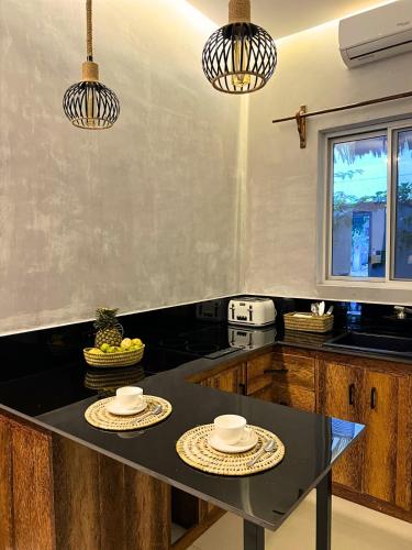 a kitchen with two plates on a black table at King Simba Apartment Hotel & Restaurant in Bwejuu