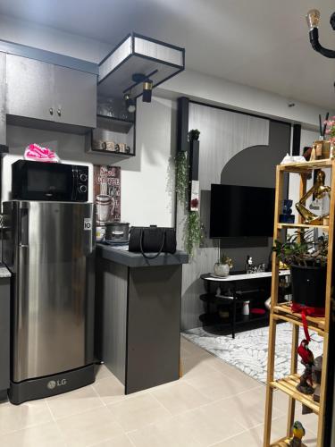 a kitchen with a stainless steel refrigerator and a counter at Plumera Mactan Bldg A 108 in Bankal