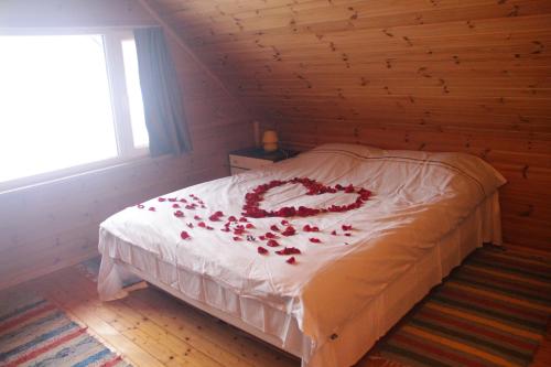 1 dormitorio con 1 cama cubierta de pétalos de rosa en Kapteni Holiday House, en Paatsalu
