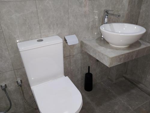 a bathroom with a white toilet and a sink at The White Porch in Kurunegala