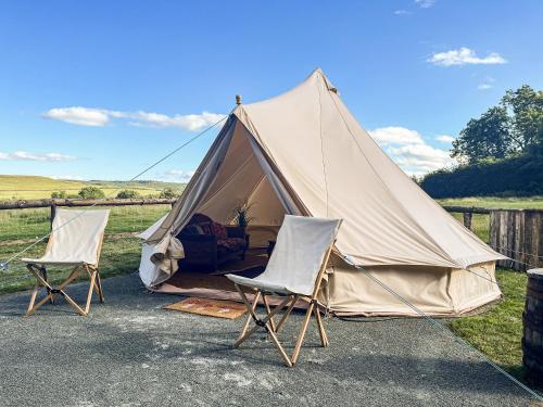a canvas tent with two chairs in front of it at The Belle Tent in Otterburn