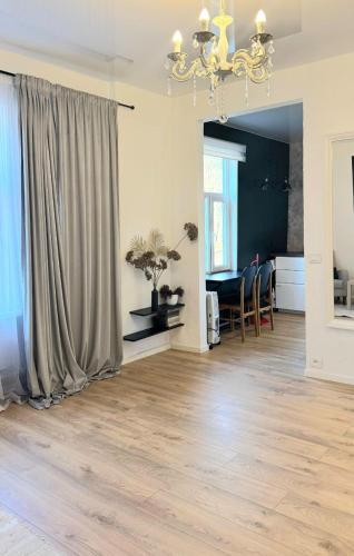 a living room with a chandelier and a table at Muna Living in Riga