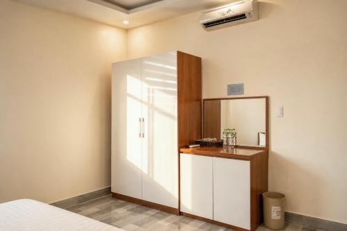 a bedroom with a white cabinet and a mirror at Cat Ba Sky Home in Cat Ba