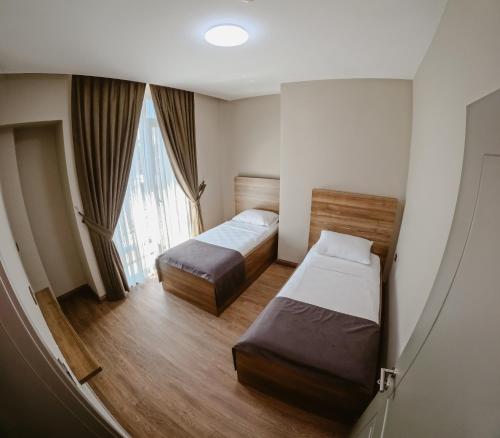 a hotel room with two beds and a window at Karasu Riva Otel in Karasu