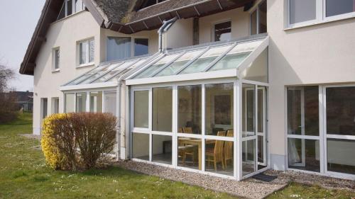 an extension to a house with sliding glass doors at Strandhaus Lobbe, App 04 - Bade- & Saunawelt täglich inklusive in Lobbe