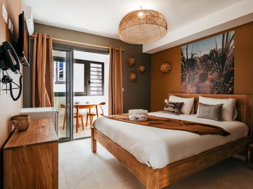 a bedroom with a large bed and a table at L'Escale Bleue in Saint-Leu