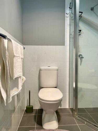 a bathroom with a toilet and a shower at The Snug Suite in Cooranbong