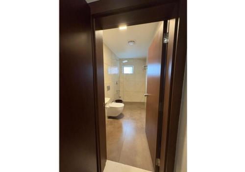 a bathroom with a toilet and a glass door at Kanak Residency Kuthuparamba in Kottayam
