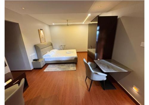 a bedroom with a bed and a desk and a chair at Kanak Residency Kuthuparamba in Kottayam
