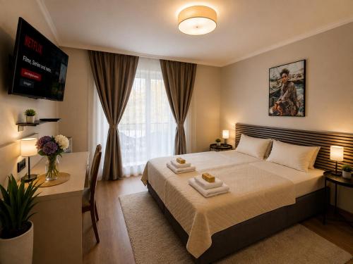 ein Schlafzimmer mit Bett, Schreibtisch und Fernseher in der Unterkunft Hotel M in Nürnberg