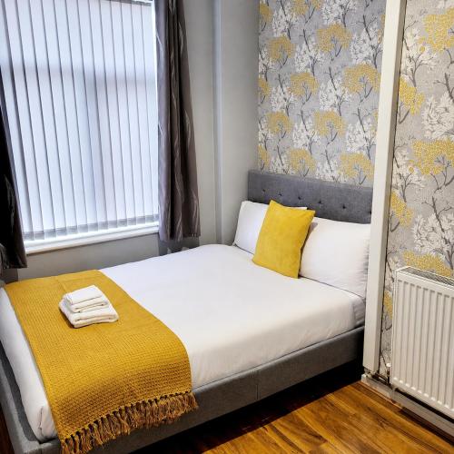 a bedroom with a bed with a yellow blanket on it at B&G Homes in Hollinwood