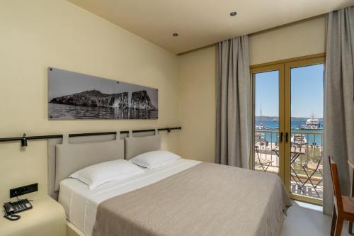 a bedroom with a bed and a view of the ocean at Portiani Suites in Adamantas
