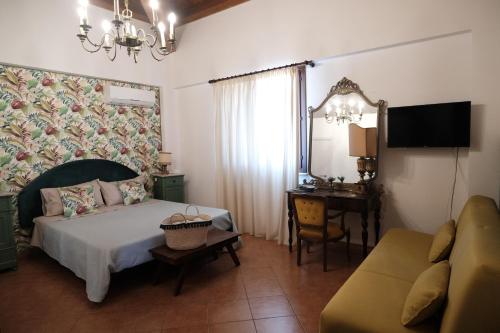 a bedroom with a bed and a desk and a couch at Antico Frantoio Rooms in Sambuca di Sicilia
