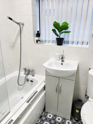 a bathroom with a sink and a tub and a toilet at B&G Homes in Hollinwood
