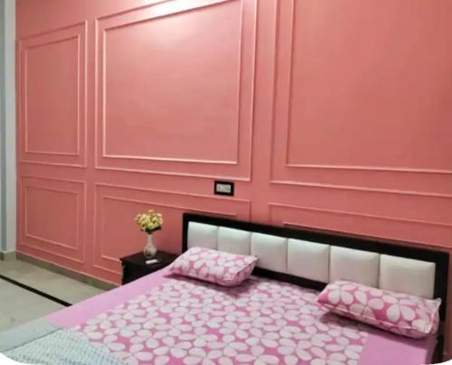 a pink bedroom with a bed with pink pillows at Whispring hills hotel in Sodākor