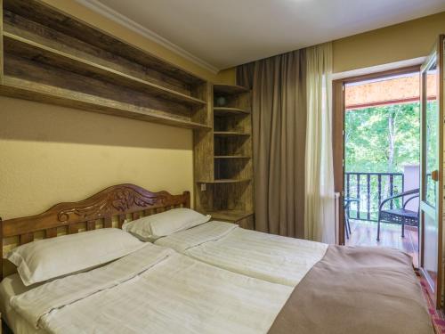 a bedroom with a bed and a book shelf at Hotel Iveria in Abastumani