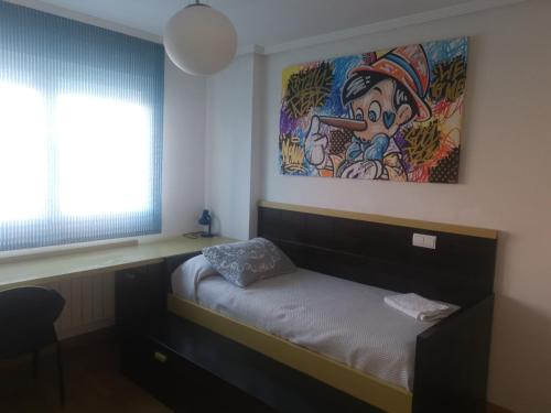 a room with a bed with a painting on the wall at Marel Valladolid in Aldeamayor de San Martín