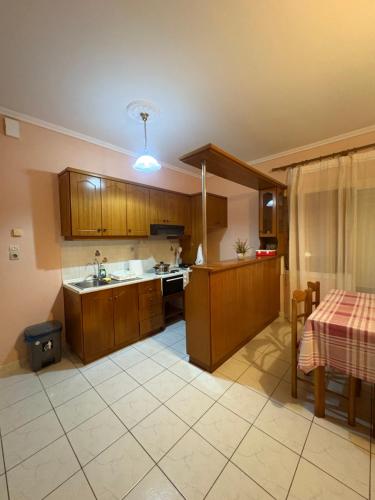 a kitchen with wooden cabinets and a table with a table cloth at Irene's Sunny residence in Limnos in Néa Koútali