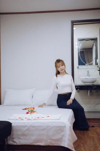 a woman sitting on a bed in a room at Thái house Mộc Châu in Bản Chiềng Di