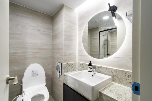 a bathroom with a white sink and a mirror at 플럼바고올스위트402 in Chosan-ni