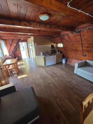 a large living room with a couch and a kitchen at Górski Ośrodek Pod Kamiennikiem in Poręba