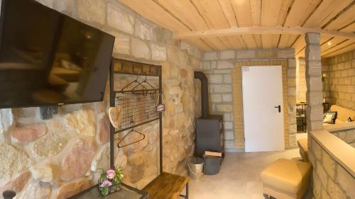 a room with a stone wall with a flat screen tv at Ferienwohnung Für 4 Personen 90 M² in Naumburg