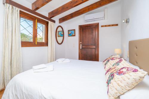 a bedroom with a white bed and a window at Casa Margarita in Andratx