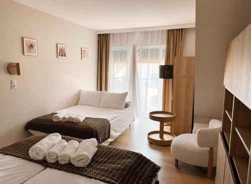 a hotel room with two beds and a chair at Silarent Niechorze Parkowa 3 in Niechorze
