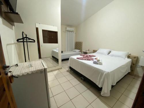 a bedroom with a large white bed in a room at Pousada Rubbi Violeta in Alto Paraíso de Goiás