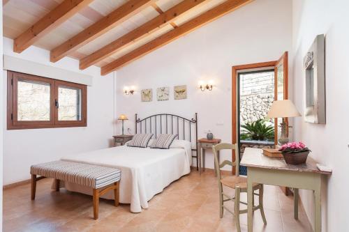 ein Schlafzimmer mit einem Bett, einem Tisch und Stühlen in der Unterkunft Cal Tio in Caimari