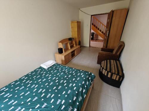 a bedroom with a bed and a chair and a staircase at Agroturystyka - Pasieka Miody Gór Opawskich in Dobiesźow
