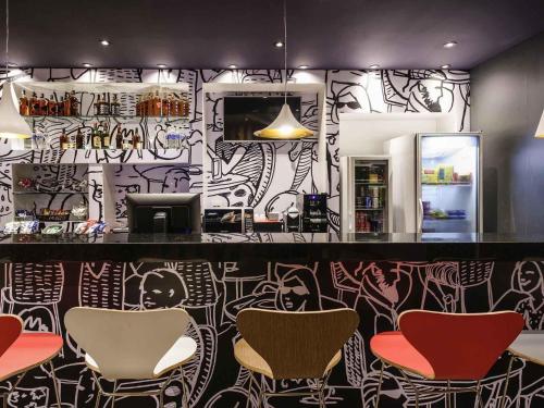 a bar with chairs and a wall covered in graffiti at ibis Recife Aeroporto in Recife