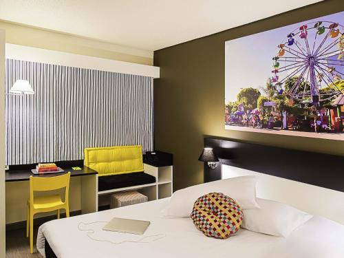 a hotel room with a bed and a ferris wheel on the wall at Ibis Styles Porto Alegre Centro - proximo rodoviaria, Araujo Vianna e hospitais in Porto Alegre