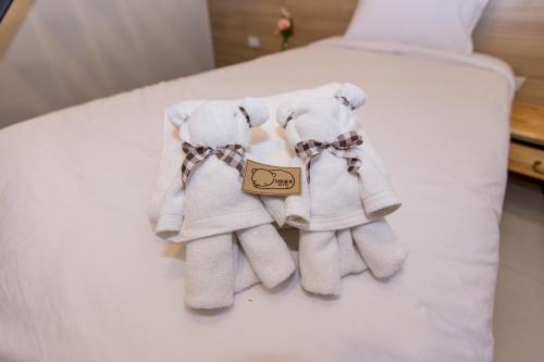 two pairs of towels sitting on a bed at TUCK Me iN in Chiang Mai